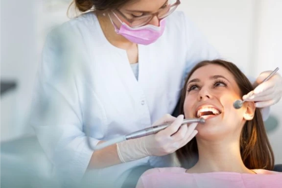 Dentist examining a smiling woman's teeth