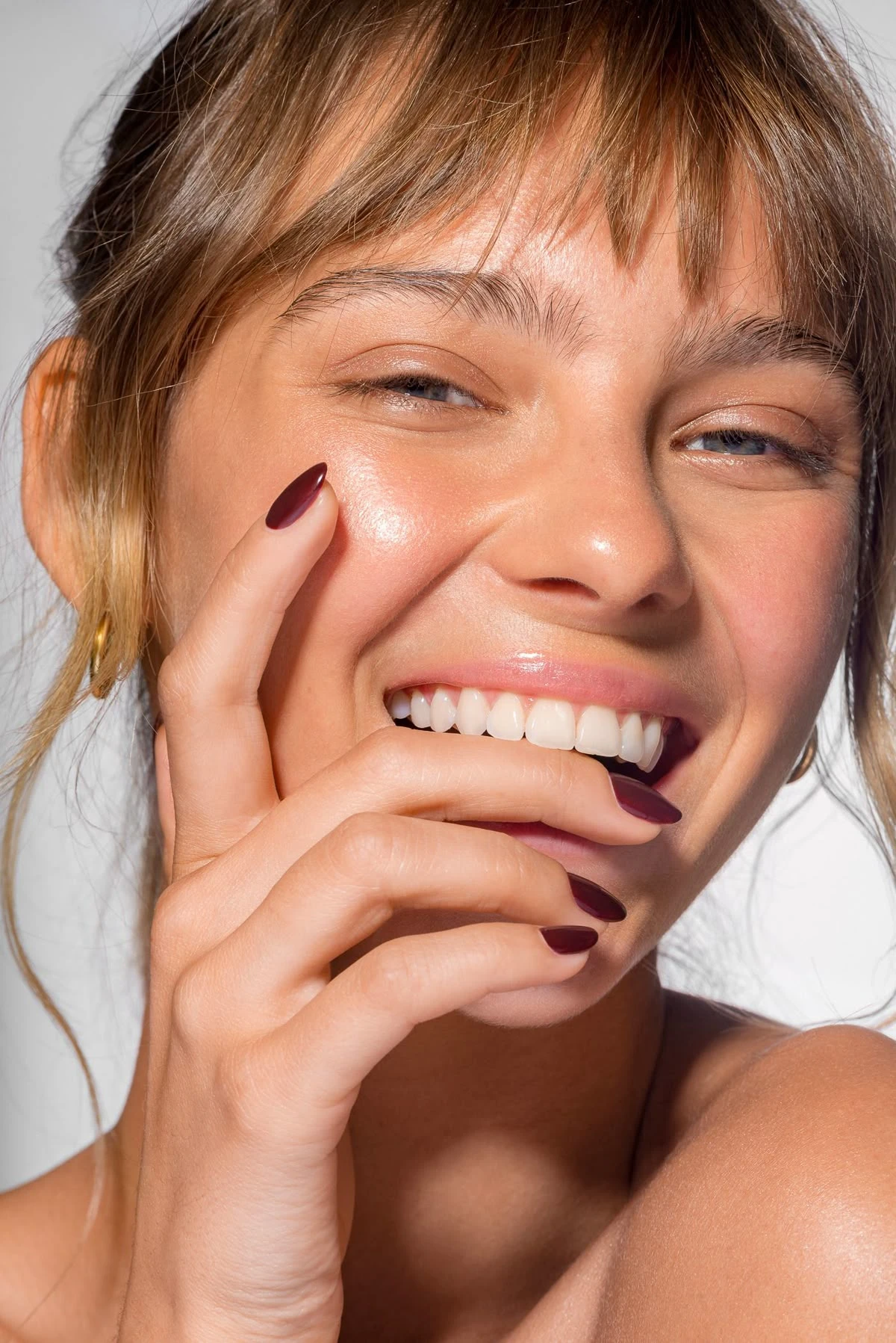 Close-up of a woman smiling, showing bright white teeth