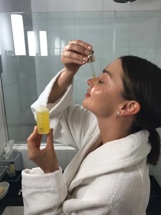 Woman applying a facial serum with a dropper