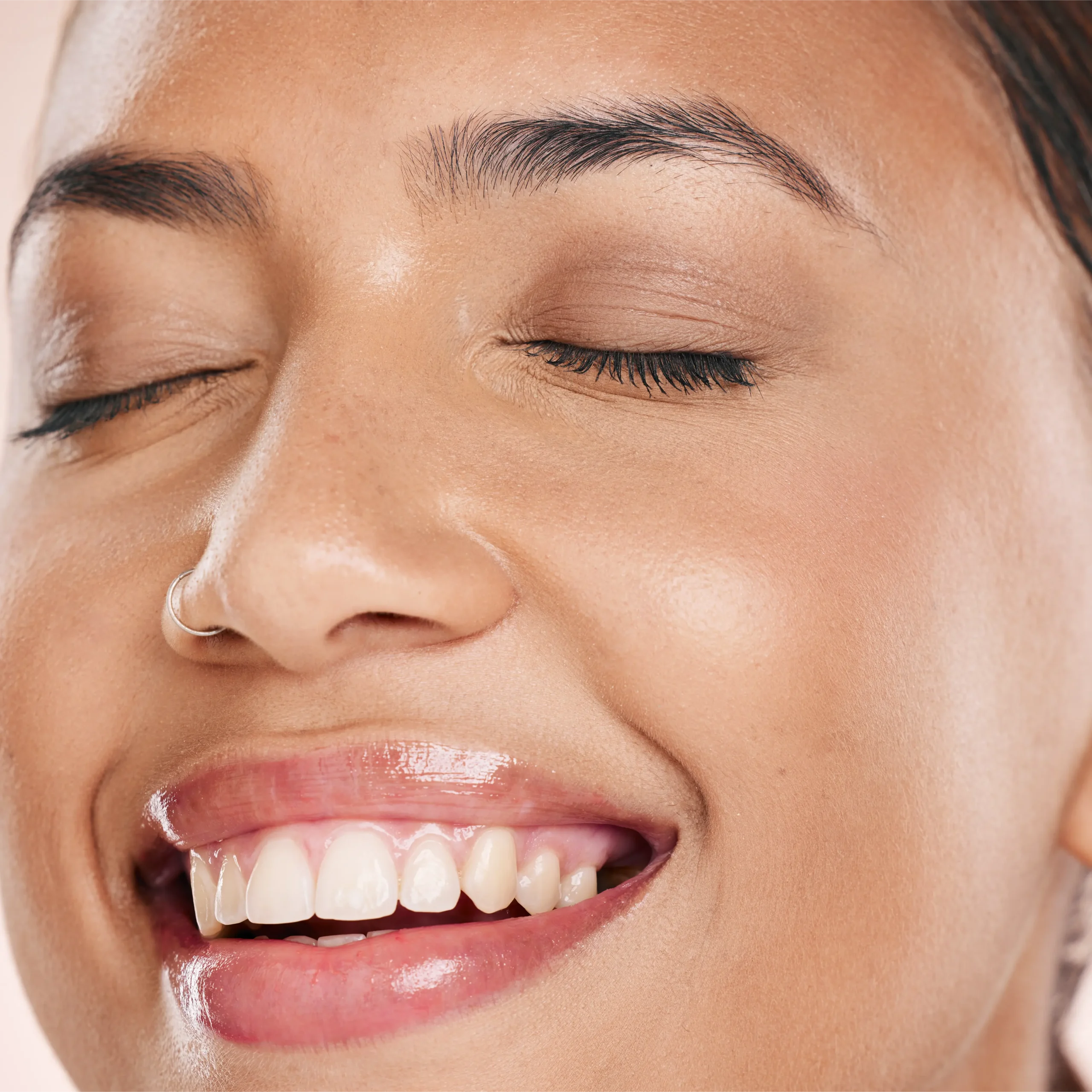 Close-up of a woman's smile with glossy lips
