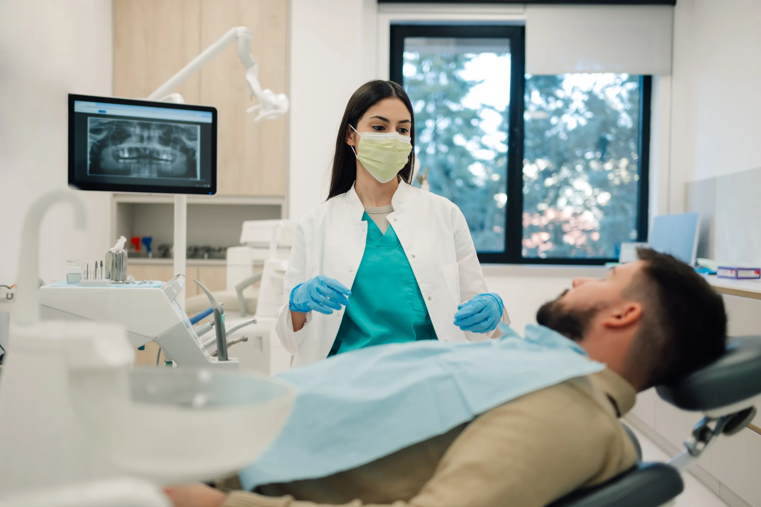 Dentist in a mask talking to a patient