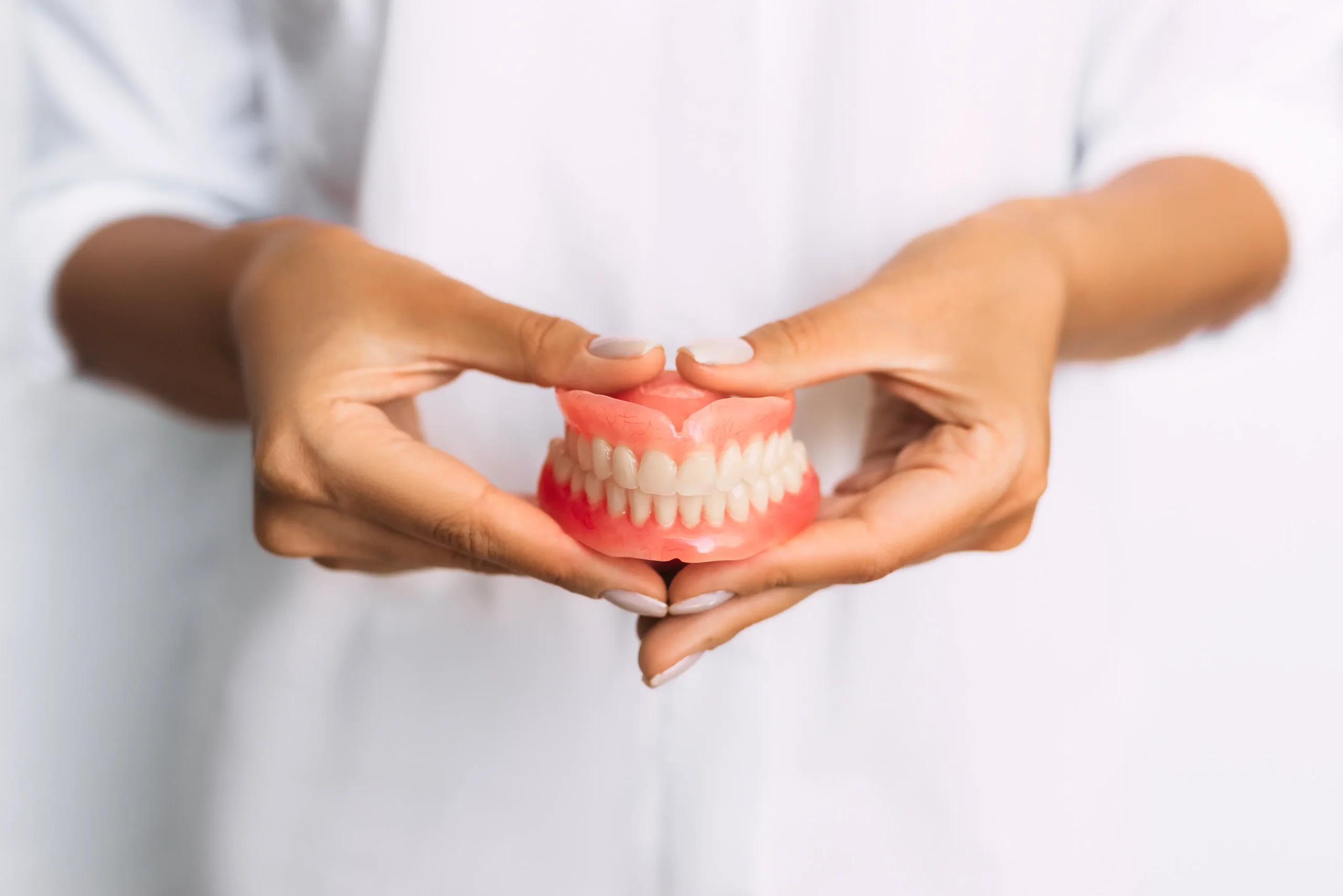 Hands holding a set of dentures