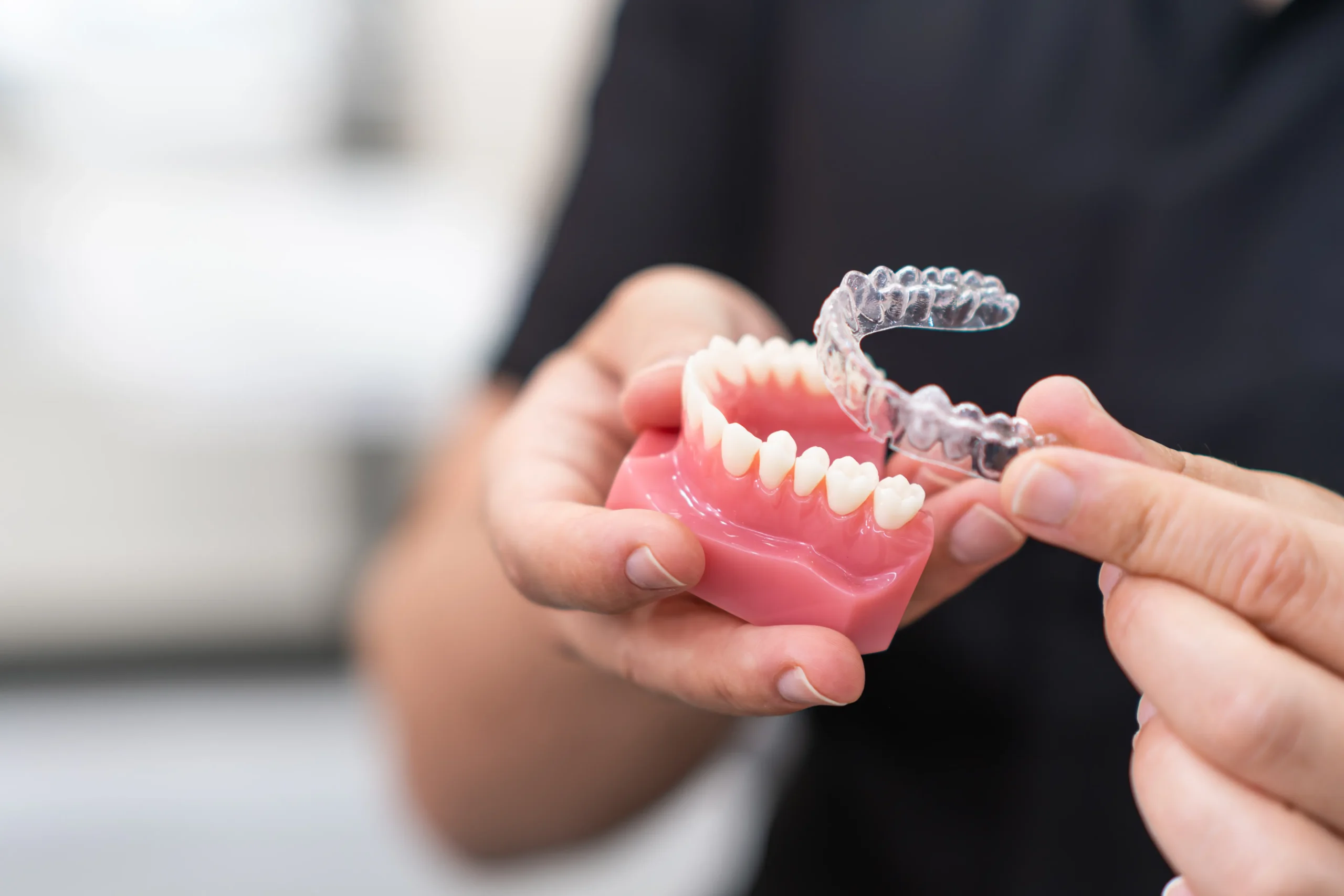 Orthodontist holding a jaw model with a clear aligner