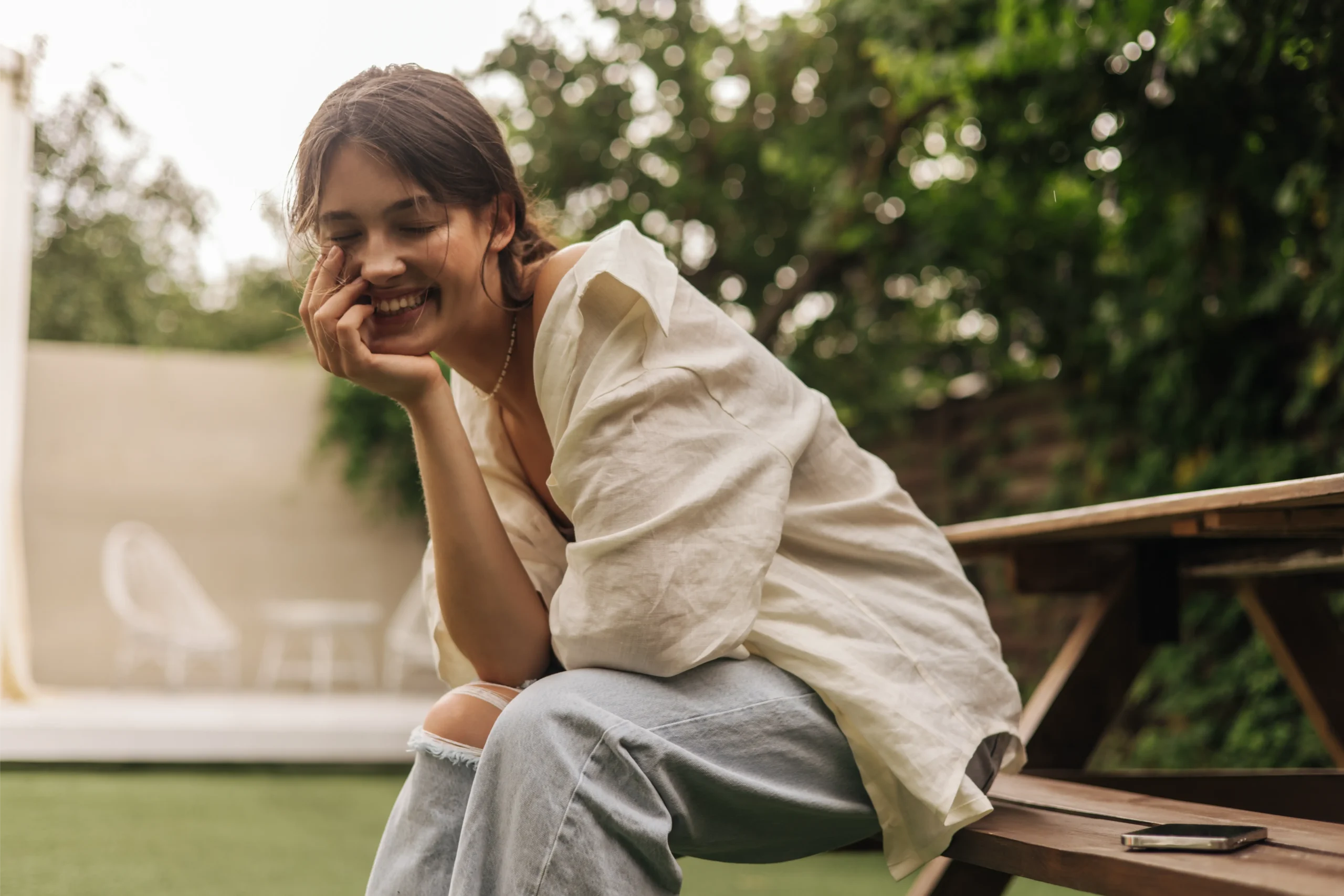Smiling woman sitting outdoors in a garden