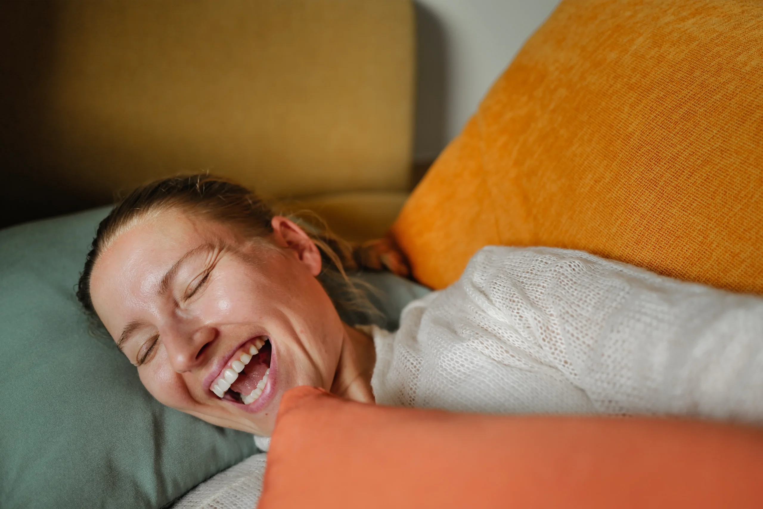 Woman laughing on a sofa