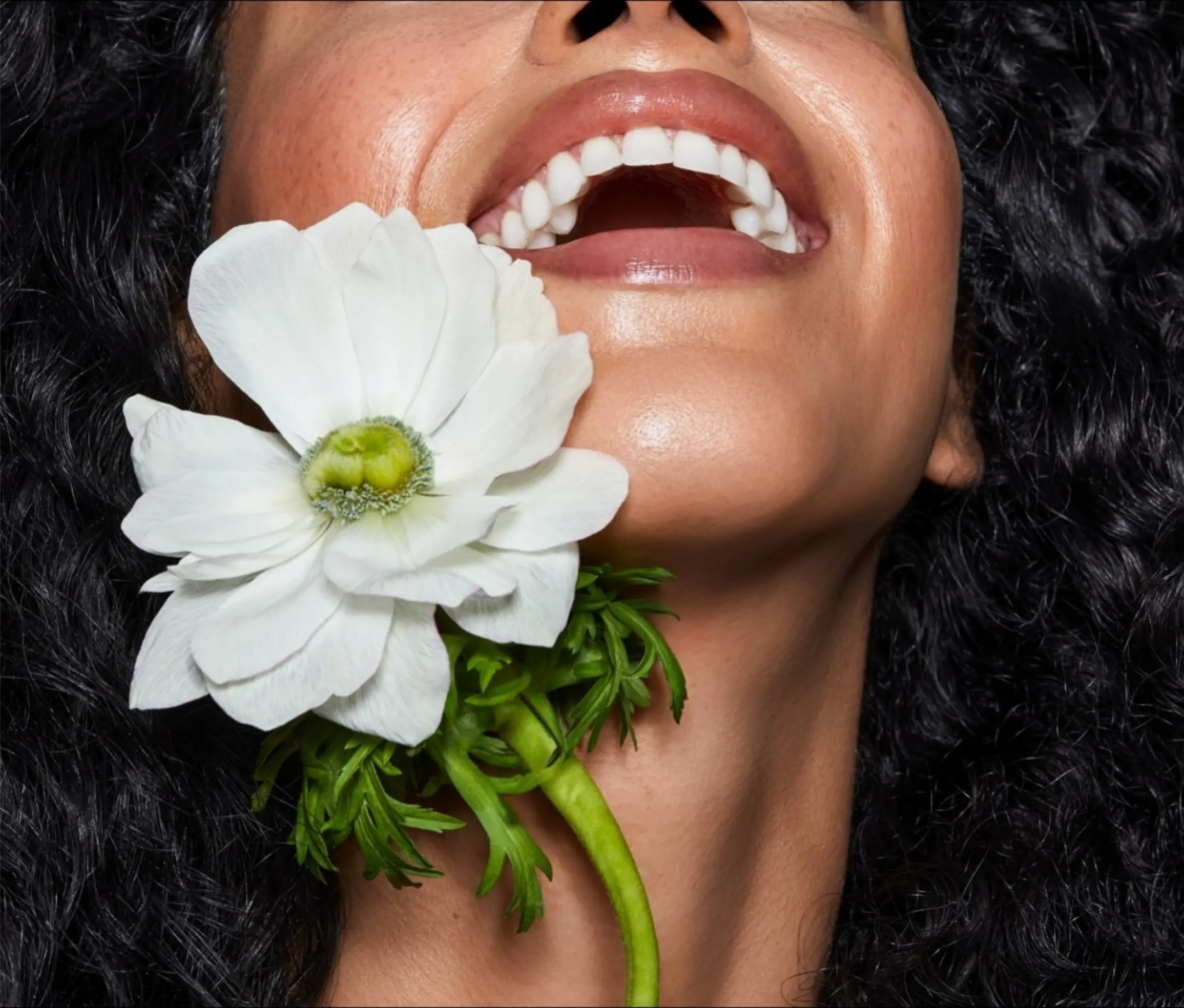 Laughing woman holding a white flower
