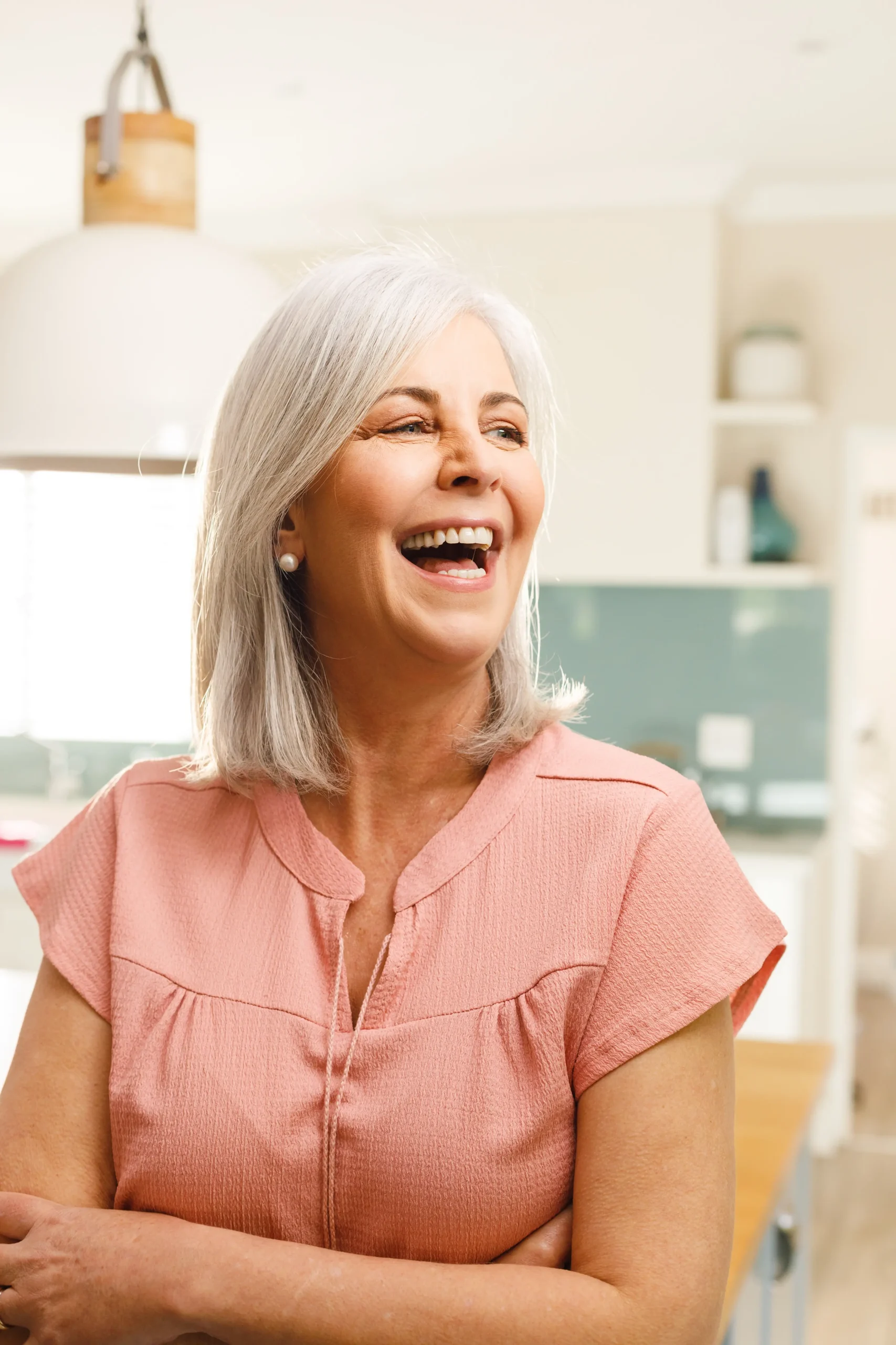 Smiling woman with grey hair wearing pink