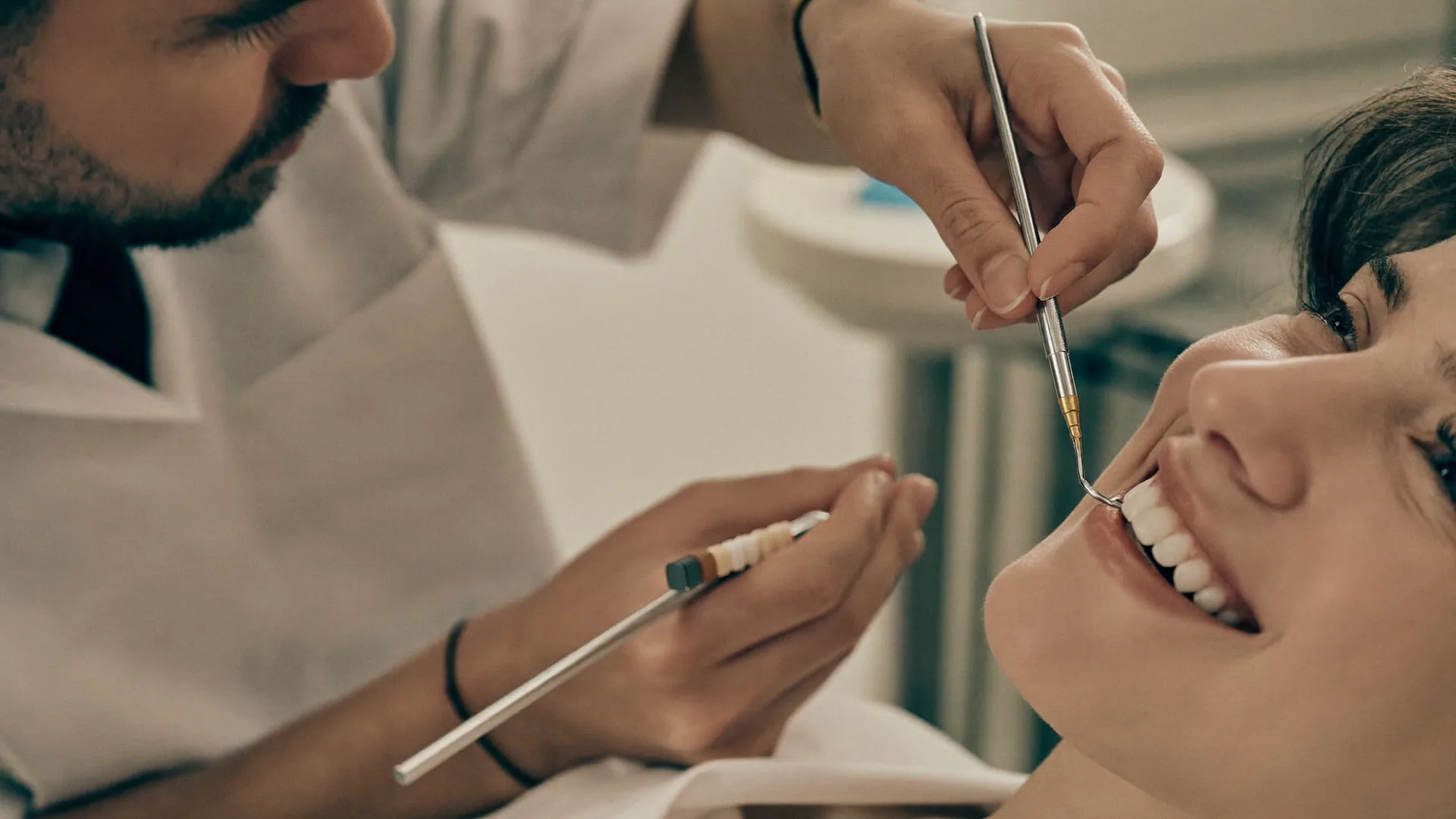 Dentist examining a smiling patient's teeth