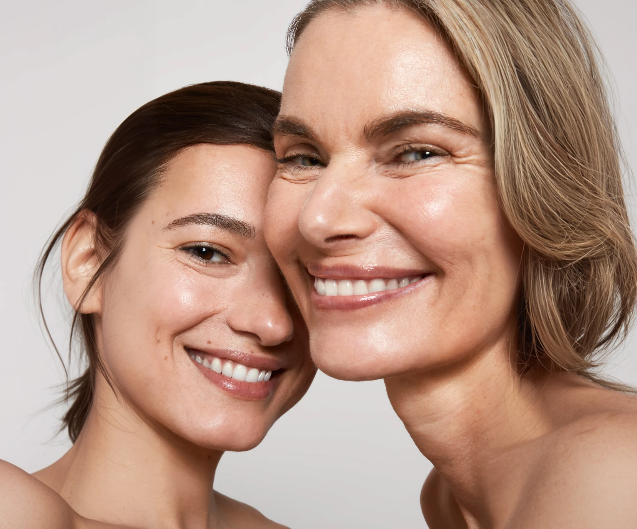 Two smiling women with healthy, glowing skin